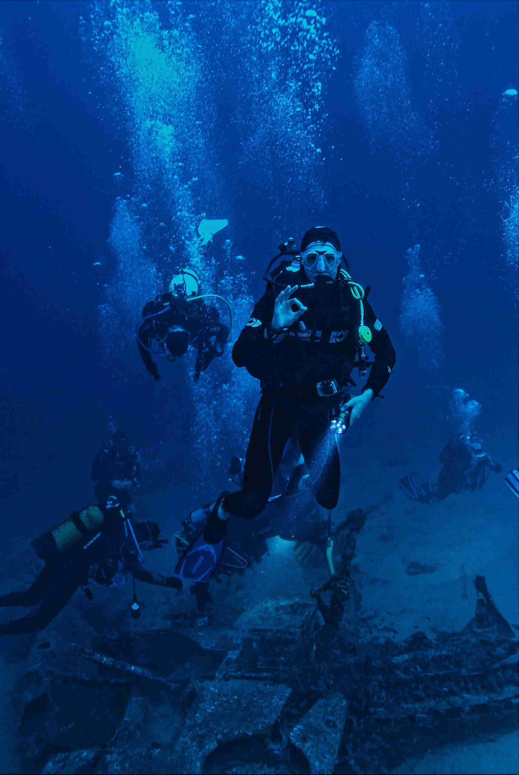 Diver under the waters off of the coast of Guanacaste Costa Rica, blue background with bubbles rising