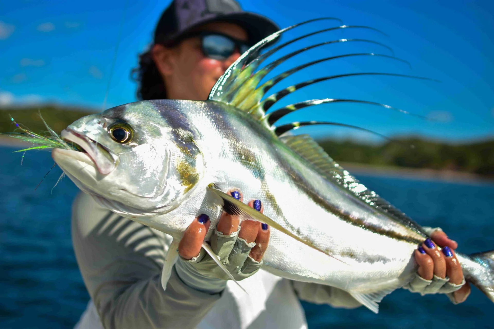 Angler holding a roosterfish caught on a fishing charter in Playa Potrero, Costa Rica