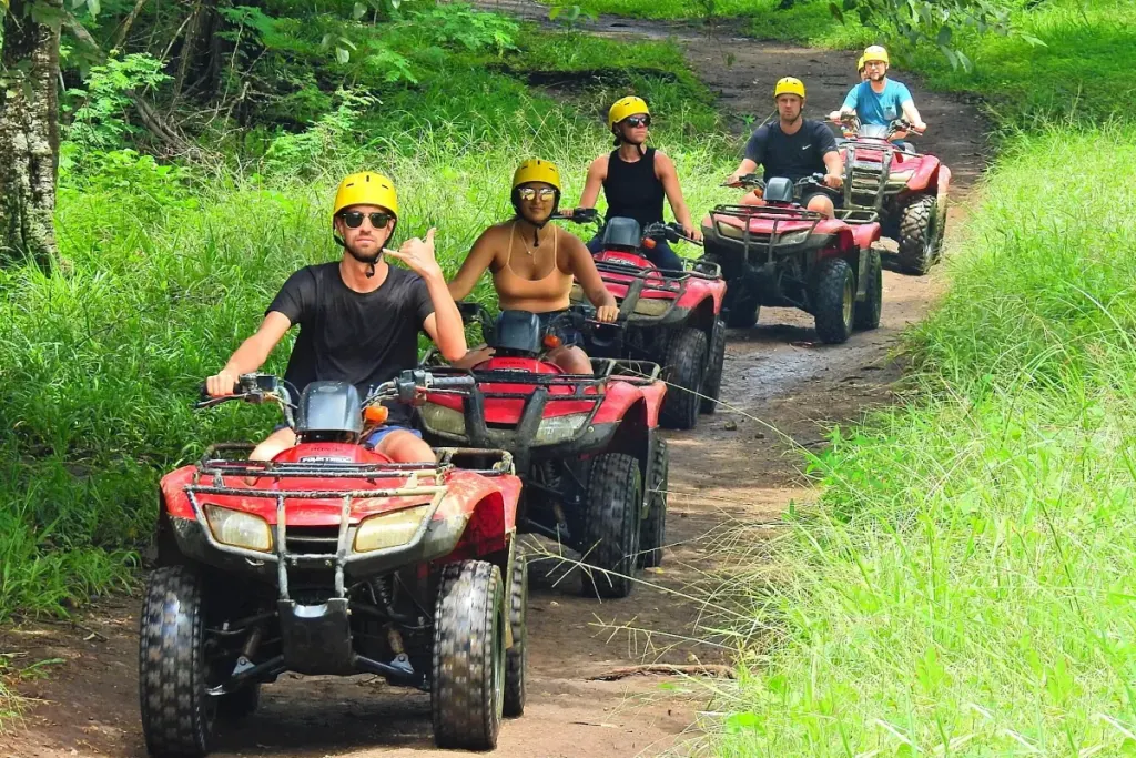 Group of riders on a guided ATV trail tour through the green Guanacaste jungle near Playa Potrero, Costa Rica