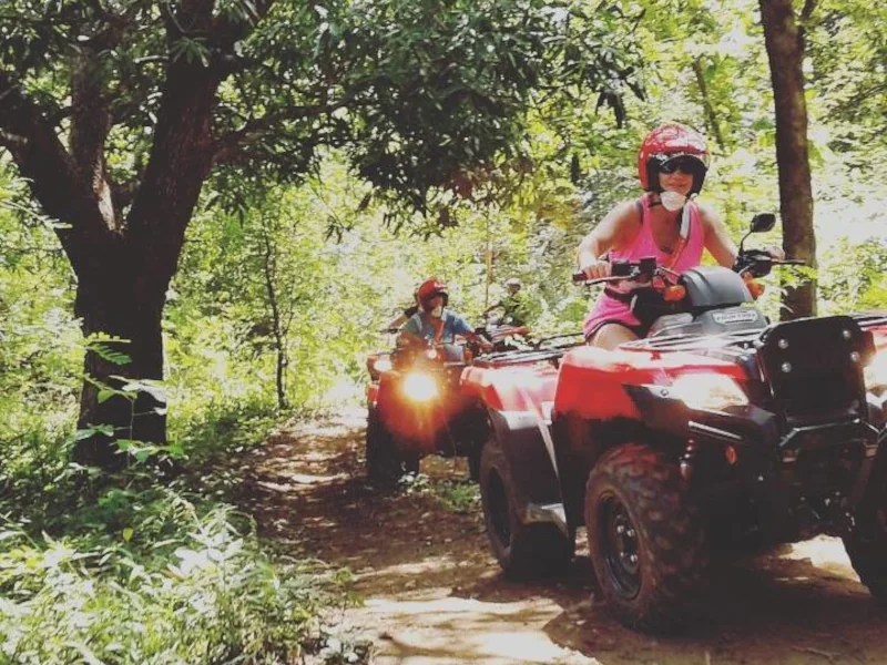 Guided ATV tour riding through a shaded jungle trail near Playa Potrero, Costa Rica