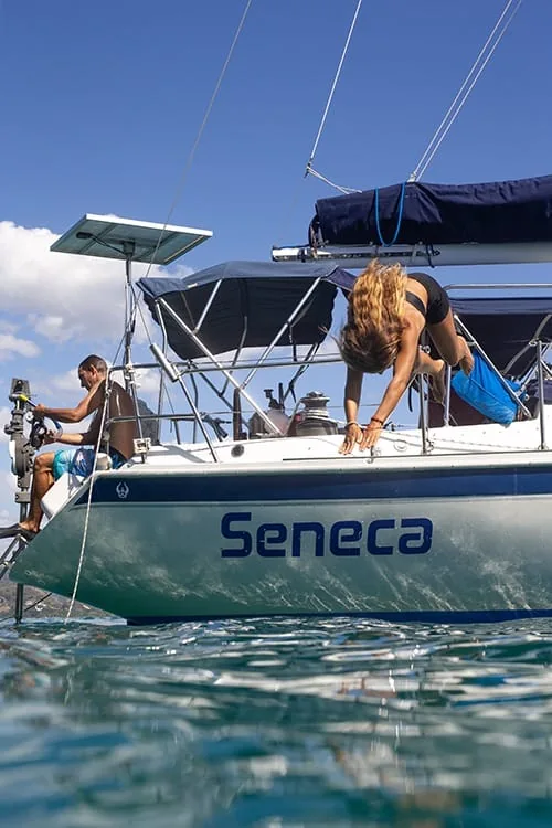 A guest diving off the stern of the Seneca sailboat into clear water off Playa Potrero, Costa Rica