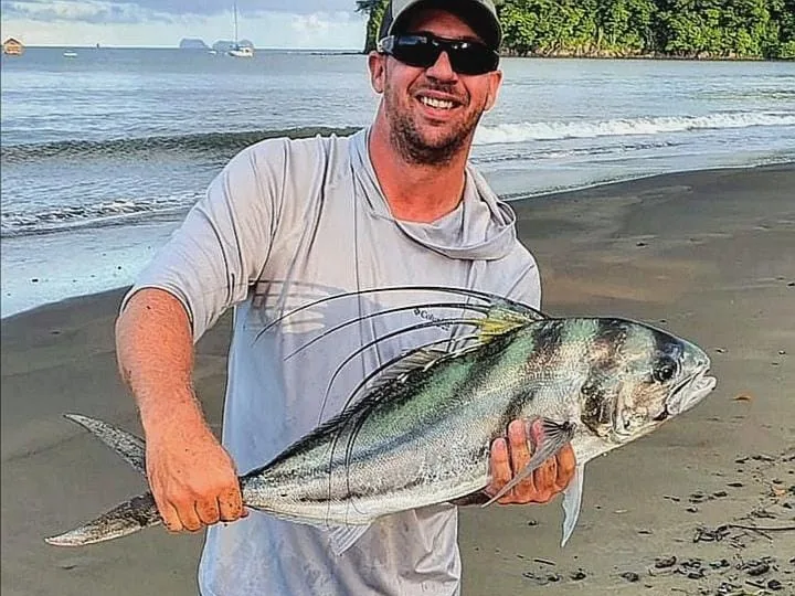 Angler with a trophy roosterfish caught beach fishing at Playa Potrero, Costa Rica
