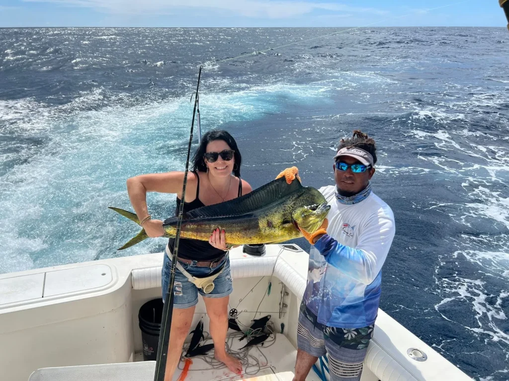 Angler with a dorado (mahi-mahi) and crew aboard the Dream On charter, Playas del Coco