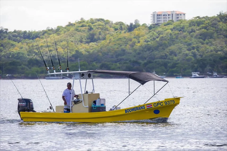 The yellow Boomerang fishing charter boat underway in Potrero Bay, Guanacaste, Costa Rica, rods rigged and ready