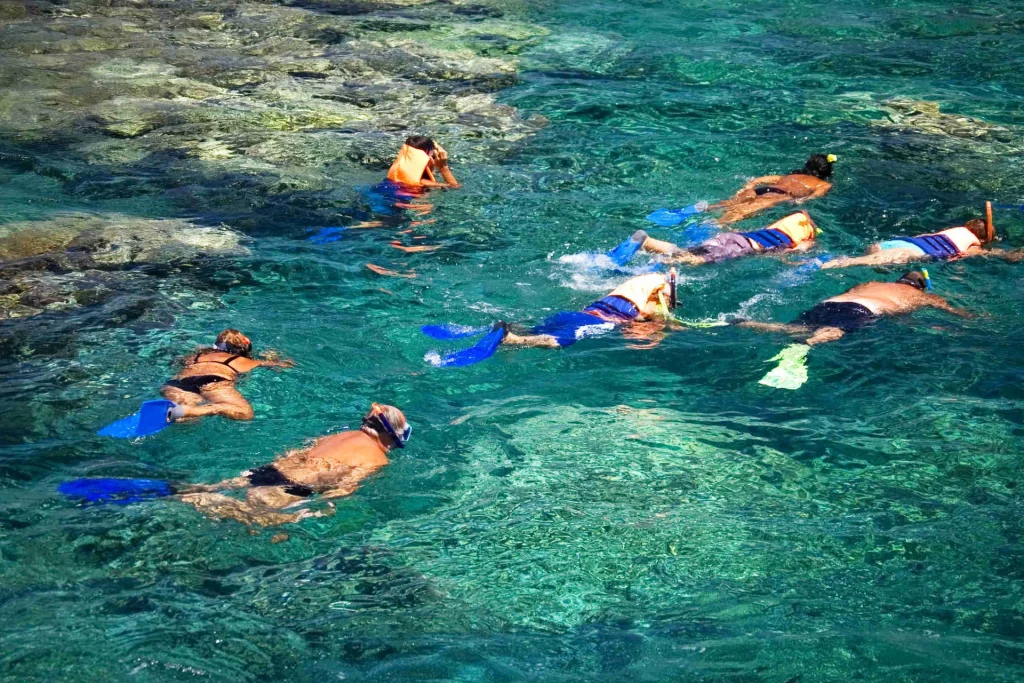 A guided group snorkeling over a shallow rocky reef in the clear water off Playa Potrero, Guanacaste, Costa Rica