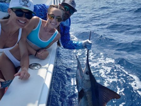 Thrilled anglers enjoying a successful Sport Fishing Guanacaste trip, landing a beautiful sailfish.